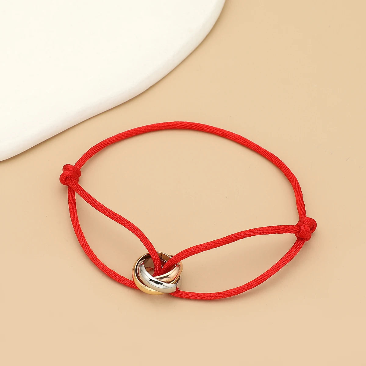 Unisex bracelet featuring three metal round circles and adjustable rope band, stylish jewelry accessory for men and women.