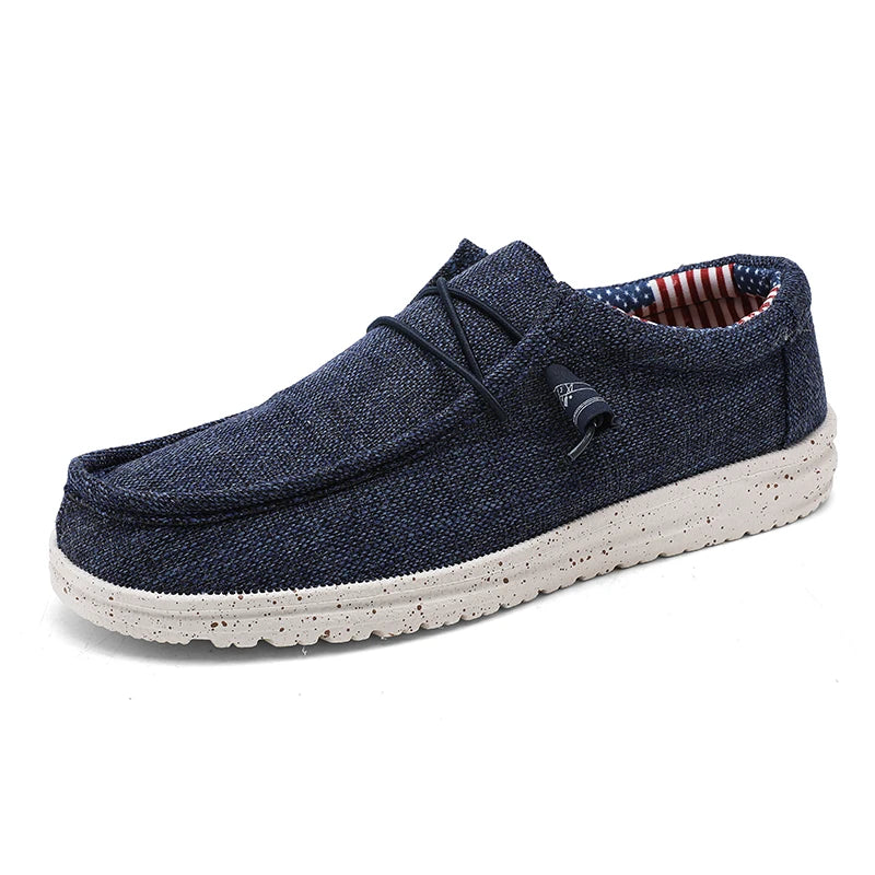 Men's denim canvas trainers by Jelieora Venture showing side view with white rubber sole and blue denim fabric upper.