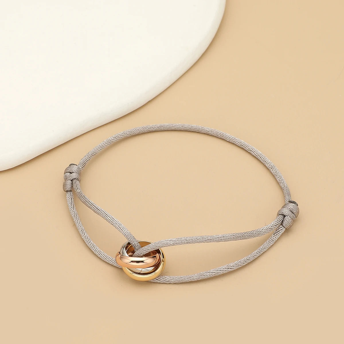Unisex bracelet with three metal round circles on adjustable rope, stylish jewelry accessory for men and women